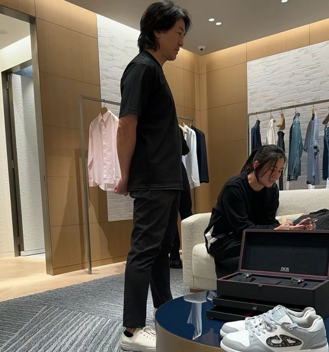 九游会J9：郑伊健与蒙嘉慧日本购物被偶遇黑衣素颜逛街头发浓密状态好(图1)